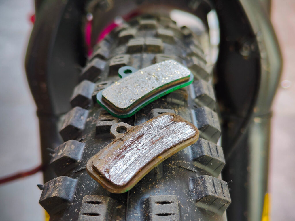 Worn vs new sintered brake pads. Other than that the pad in the front is worn, the surface is also glazed