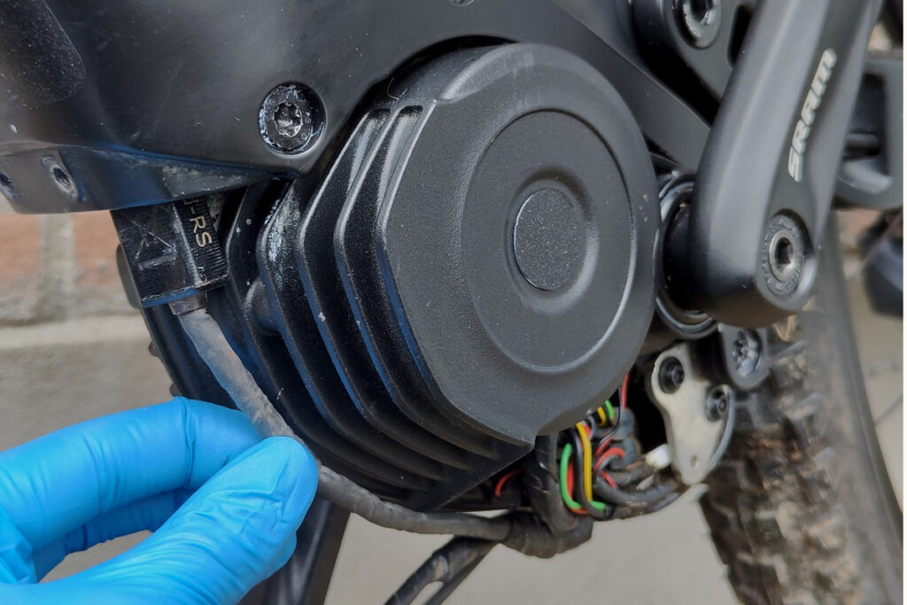 Mechanic shows where to place the tuning dongle on a Bosch e-bike motor